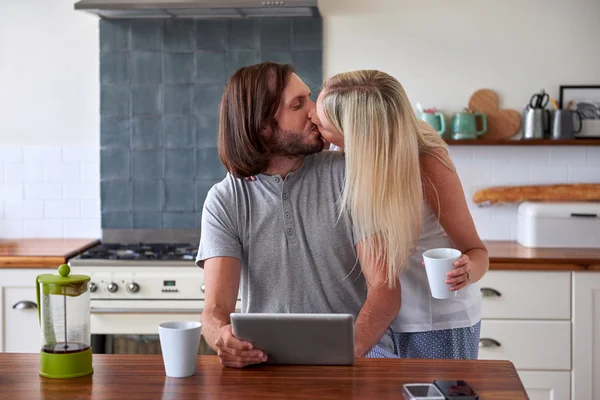 Casal beijando café da manhã com tablet computador — Fotografia de Stock