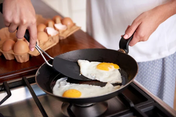 Женщина готовит яйца завтрак — стоковое фото