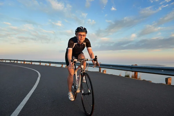 Woman riding a bike on the road — Stock Photo, Image