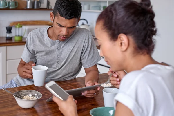 Cuplu cu cafea, tabletă, telefon mobil în bucătărie — Fotografie, imagine de stoc