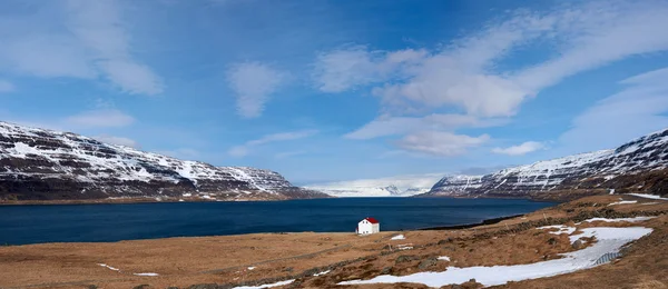 Srubu poblíž jezero a zasněžené Západních fjordů v islandských hor — Stock fotografie