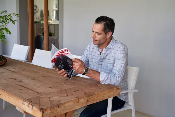 Hombre leyendo revista de negocios — Foto de Stock