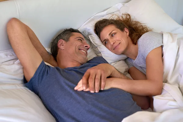 Šťastné milující pár leží v posteli — Stock fotografie