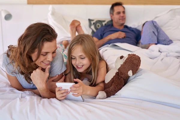 Mãe e criança na cama com dispositivo tablet — Fotografia de Stock