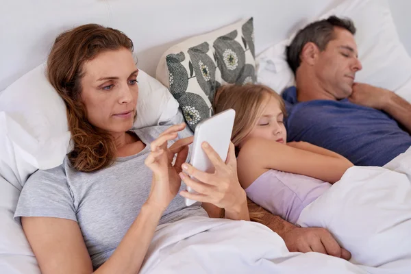 Family relaxing at home in bed — Stock Photo, Image