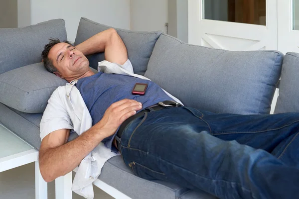 Κουρασμένος άνθρωπος κοιμάται στον καναπέ — Φωτογραφία Αρχείου