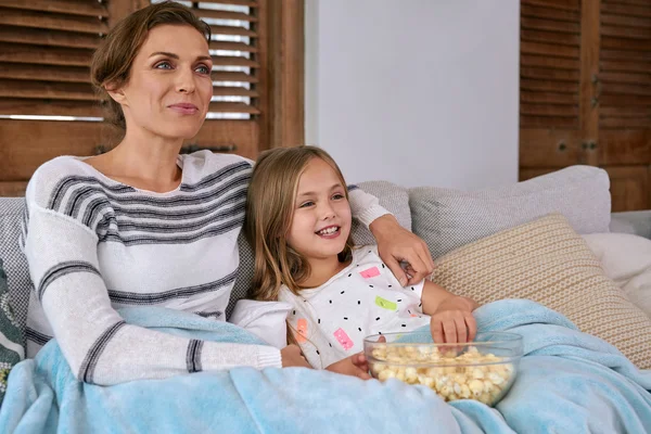 Mother and daughter watching movies and eating popcorn — Stock Photo, Image