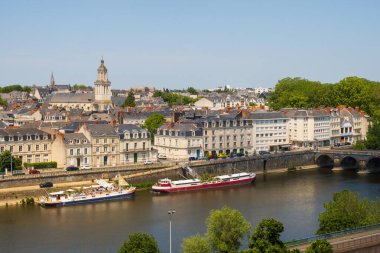 Angers, Fransa 'nın Maine-et-Loire bölgesinde mavnalarla Trinity kilisesini ve Maine nehri üzerindeki Verdun köprüsünü gözleyin.
