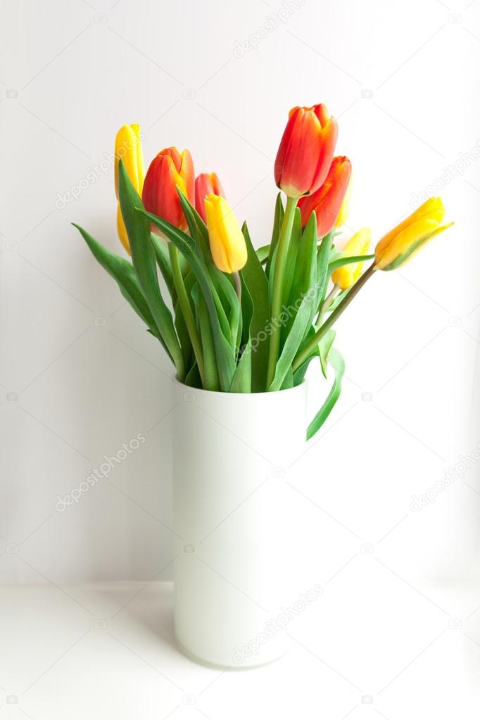 Flower bouquet from tulips in vase isolated on white background.