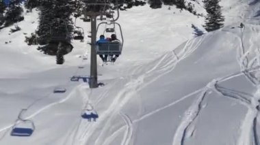 Avusturya Alplerinde kayak asansöründeki insanlar