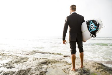 Onun surfboard holding iş adamı