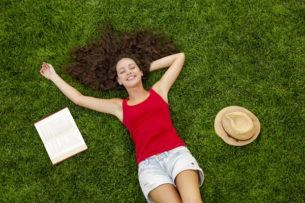 Junge Frau liegt auf dem Gras — Stockfoto