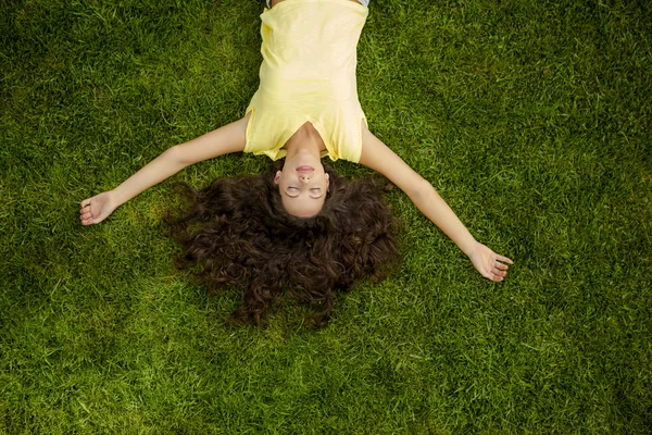Mujer joven acostada en la hierba — Foto de Stock