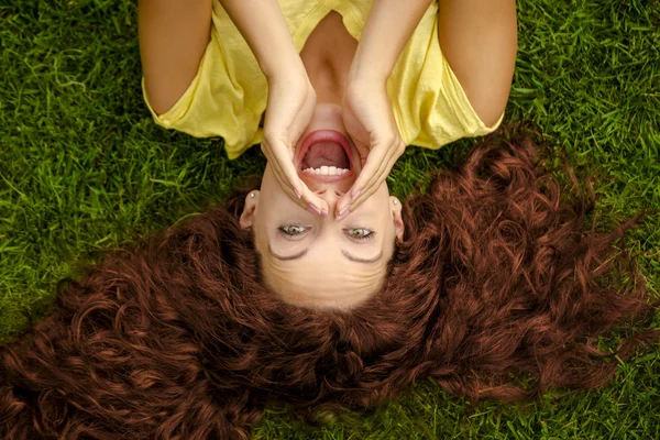 Руда жінка лежить на траві — стокове фото