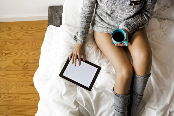 Frau trinkt Kaffee und benutzt einen Tisch — Stockfoto