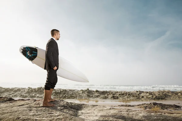 Businessman holding his surfboard — Stock Photo, Image