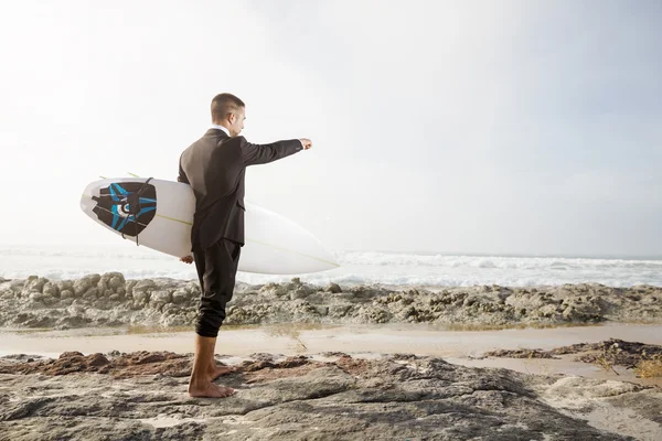 Empresario sosteniendo su tabla de surf —  Fotos de Stock