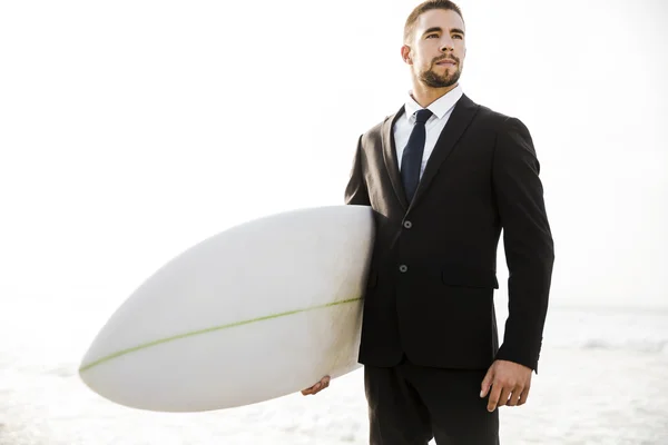 Empresário segurando sua prancha de surf — Fotografia de Stock