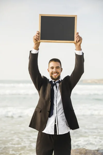 Empresário confiante segurando um quadro — Fotografia de Stock