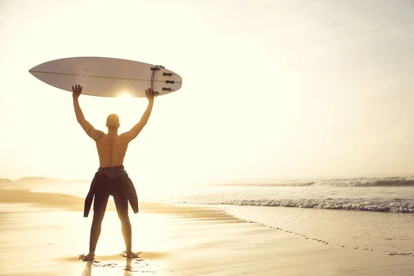 Manliga surfare med sin surfbräda på stranden — Stockfoto