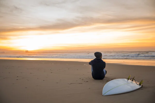 Surfer bei Sonnenuntergang mit Blick auf die Wellen. — Stockfoto