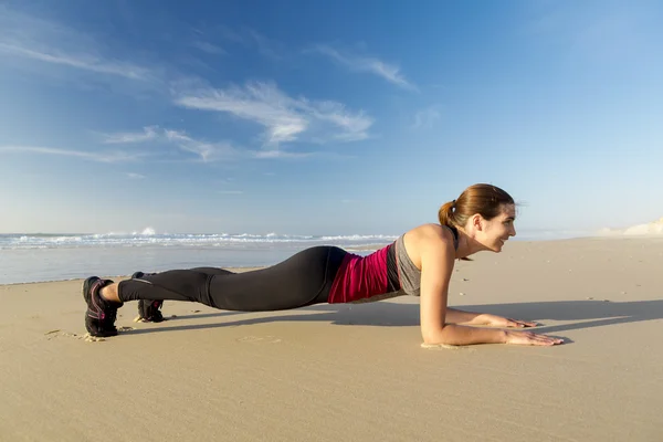 Kvinnan utöva sig själv på stranden — Stockfoto