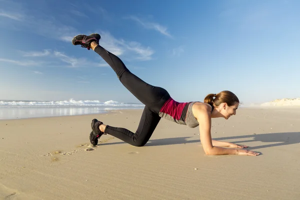 Žena sama cvičení na pláži — Stock fotografie