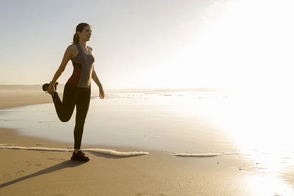 Donna che fa esercizi di stretching in spiaggia — Foto Stock