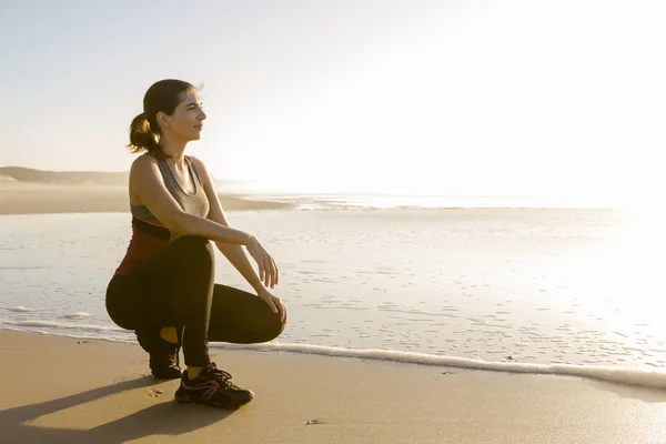 Kadın egzersiz sonrası sahilde rahatlatıcı — Stok fotoğraf