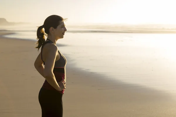 Woman relaxing at the beach after exercise — Stock Photo, Image