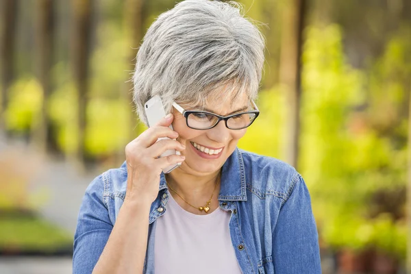 Mature woman talking at phone — Stock Photo, Image
