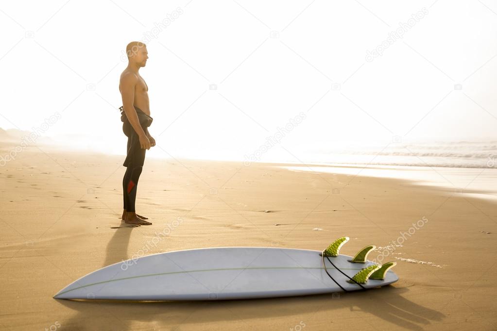 Male surfer with his surfboard at the beach