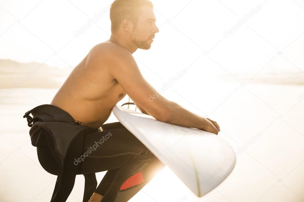 Male surfer with his surfboard at the beach