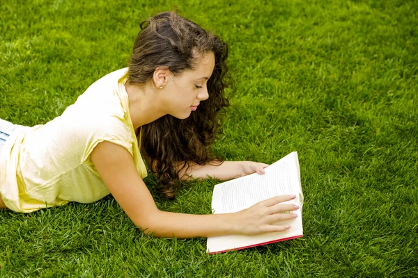 Frau liest ein Buch über Gras — Stockfoto