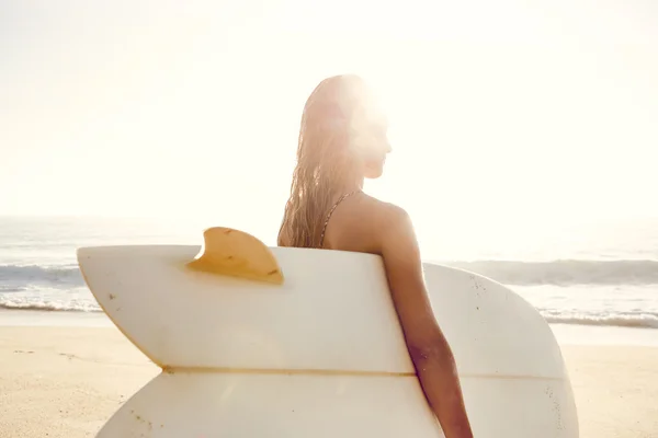 Junge Frau hält ihr Surfbrett — Stockfoto