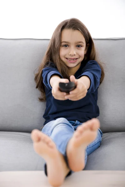 Menina segurando um controle remoto TV — Fotografia de Stock