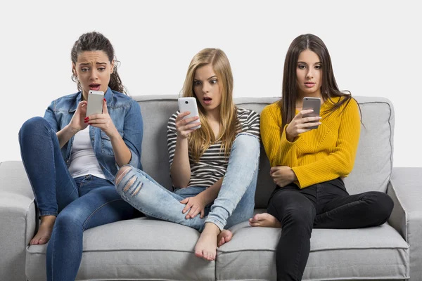 Meninas felizes usando celulares em casa — Fotografia de Stock