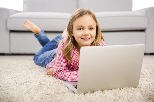 Lilla flickan arbetar med en bärbar dator — Stockfoto