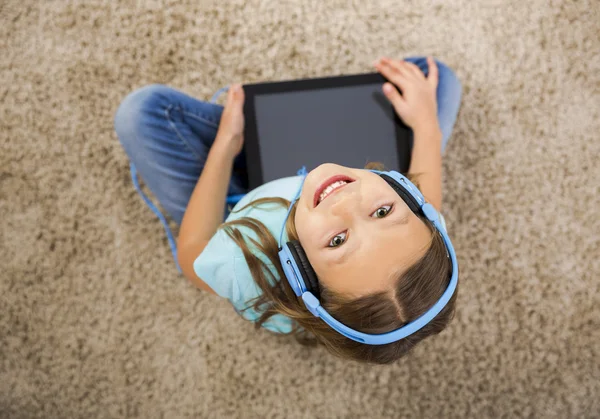 Liten flicka lyssna på musik med hörlurar — Stockfoto