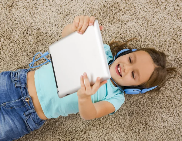 Маленькая девочка слушать музыку с наушниками — стоковое фото