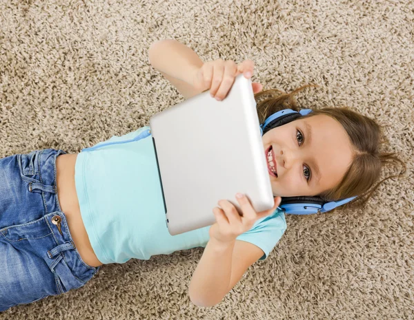 Маленькая девочка слушать музыку с наушниками — стоковое фото