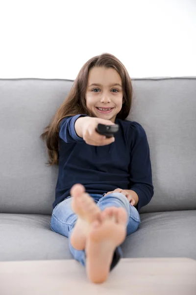 Menina segurando um controle remoto TV — Fotografia de Stock