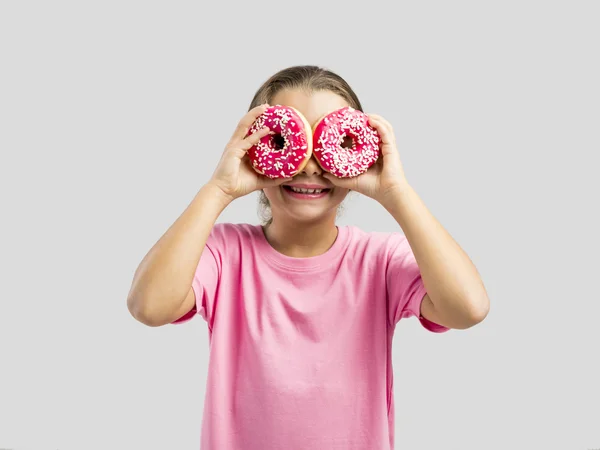 Meisje kijkend naar een donuts — Stockfoto