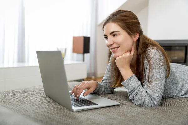 Kvinna som arbetar hemma med en bärbar dator — Stockfoto