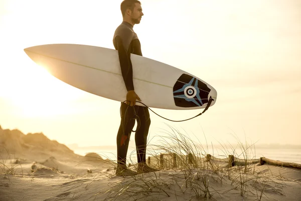 Surfista nas dunas olhando para as ondas — Fotografia de Stock