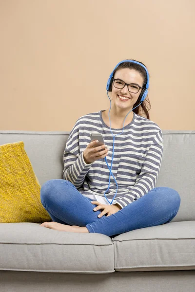 Mujer sentada en un sofá y escuchando música —  Fotos de Stock