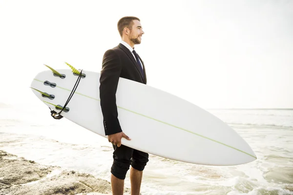 Holding a szörf, homokos strandon üzletember — Stock Fotó