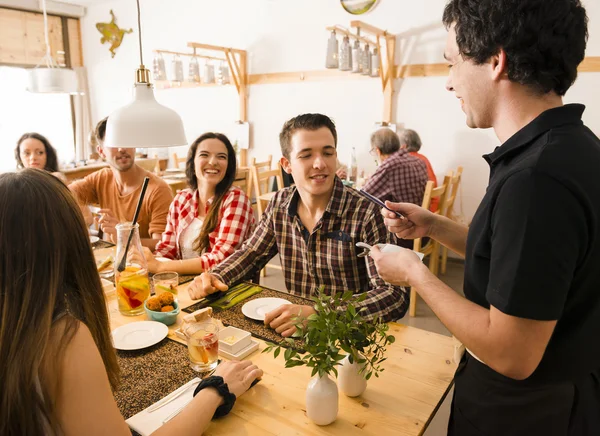 Groep van vrienden in het restaurant — Stockfoto