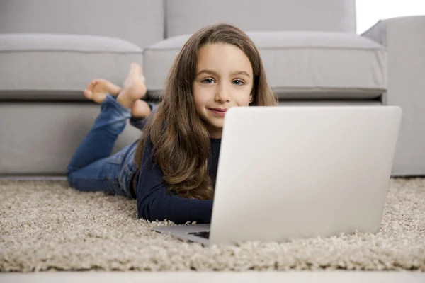 Lilla flickan arbetar med en bärbar dator — Stockfoto