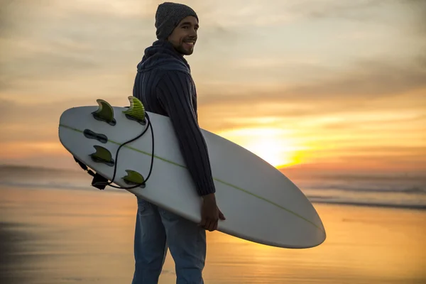 Surfing with his surfboard at the beach — Stock Photo, Image